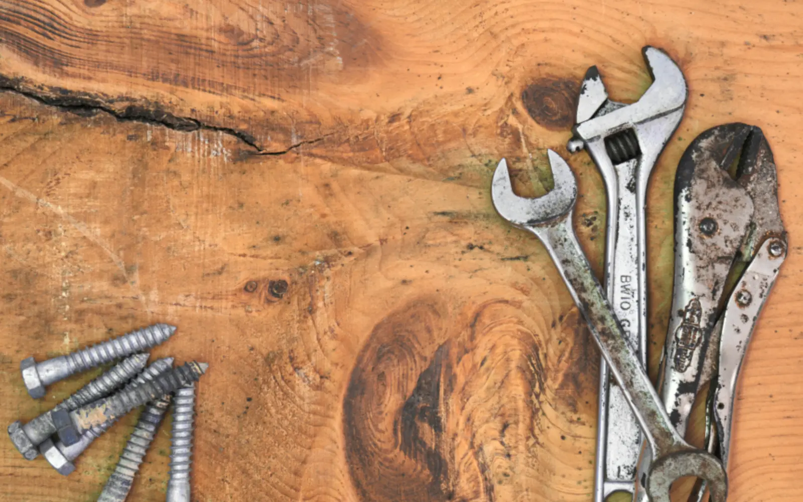 Wrenches and tools on a wooden surface